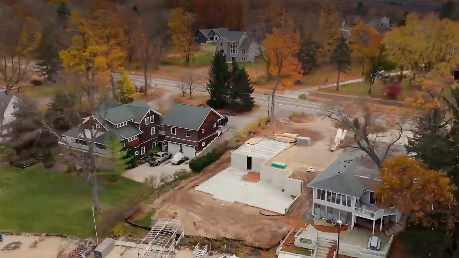 Drone photo of a new house being built in a wooded neighborhood in the fall.